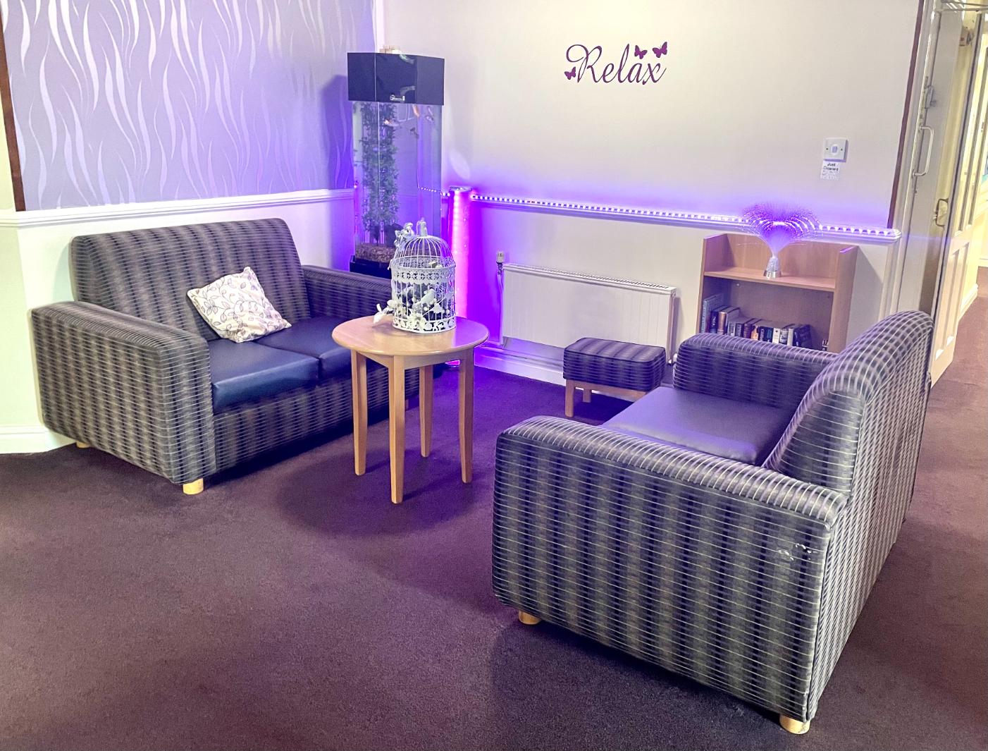 lounge area with sofas and purple lighting
